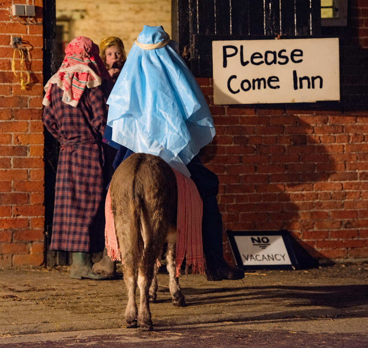 Mary riding a donkey in the live nativity outside the inn